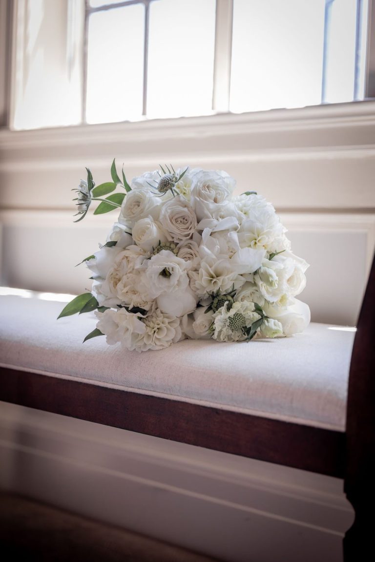 White rose bouquet on bench in bright sunlight