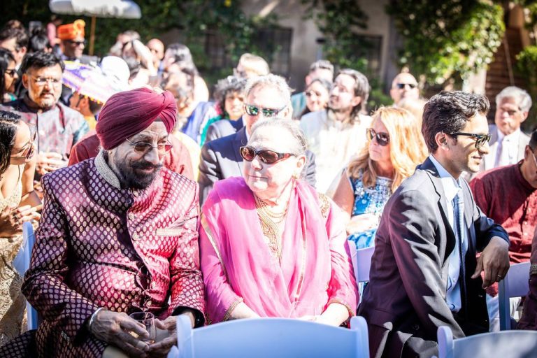 Seated guests in traditional attire watching ceremony