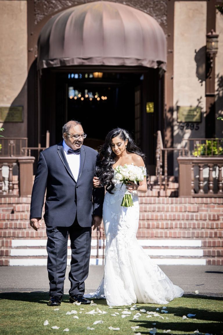 Bride and escort smiling while processing down aisle
