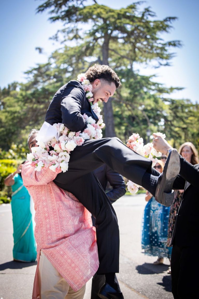 Man lifted joyfully during energetic garland greeting