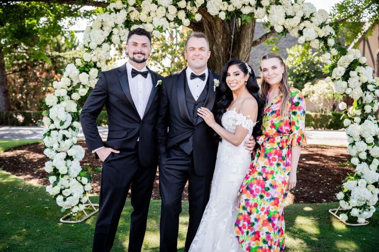 Couple with two friends laughing at floral arch