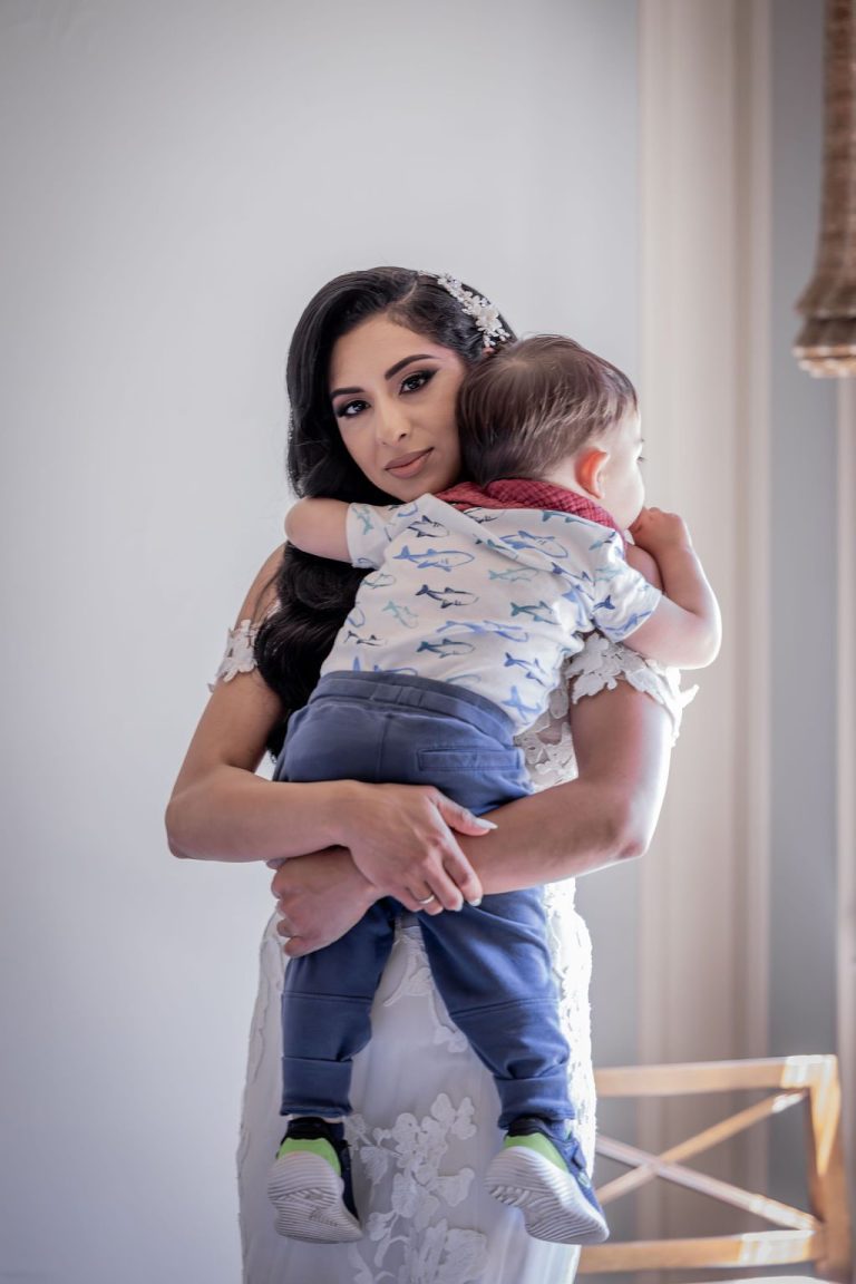 Bride holding young boy who looks over shoulder