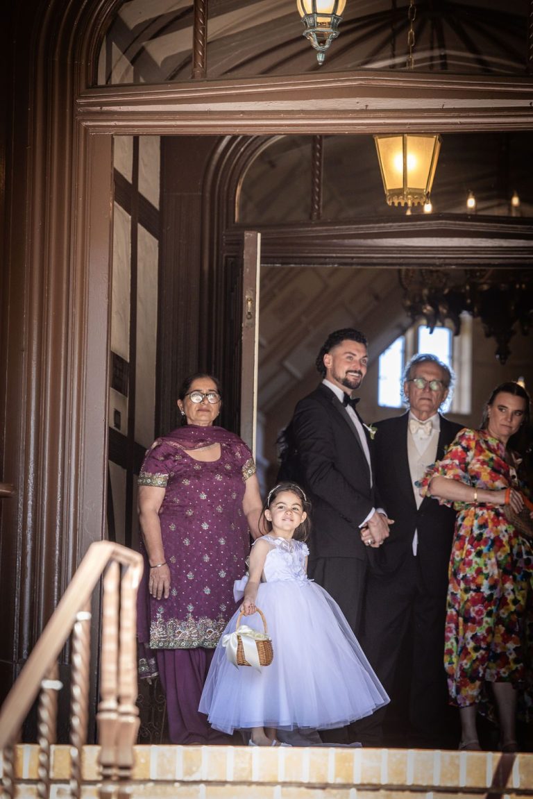 Family with flower girl framed in dark doorway