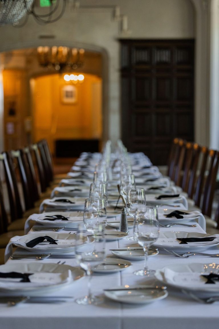 Long banquet table set with white linens and glassware