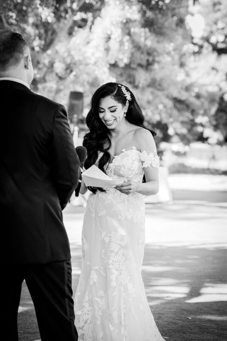 Black and white portrait of groom smiling at bride