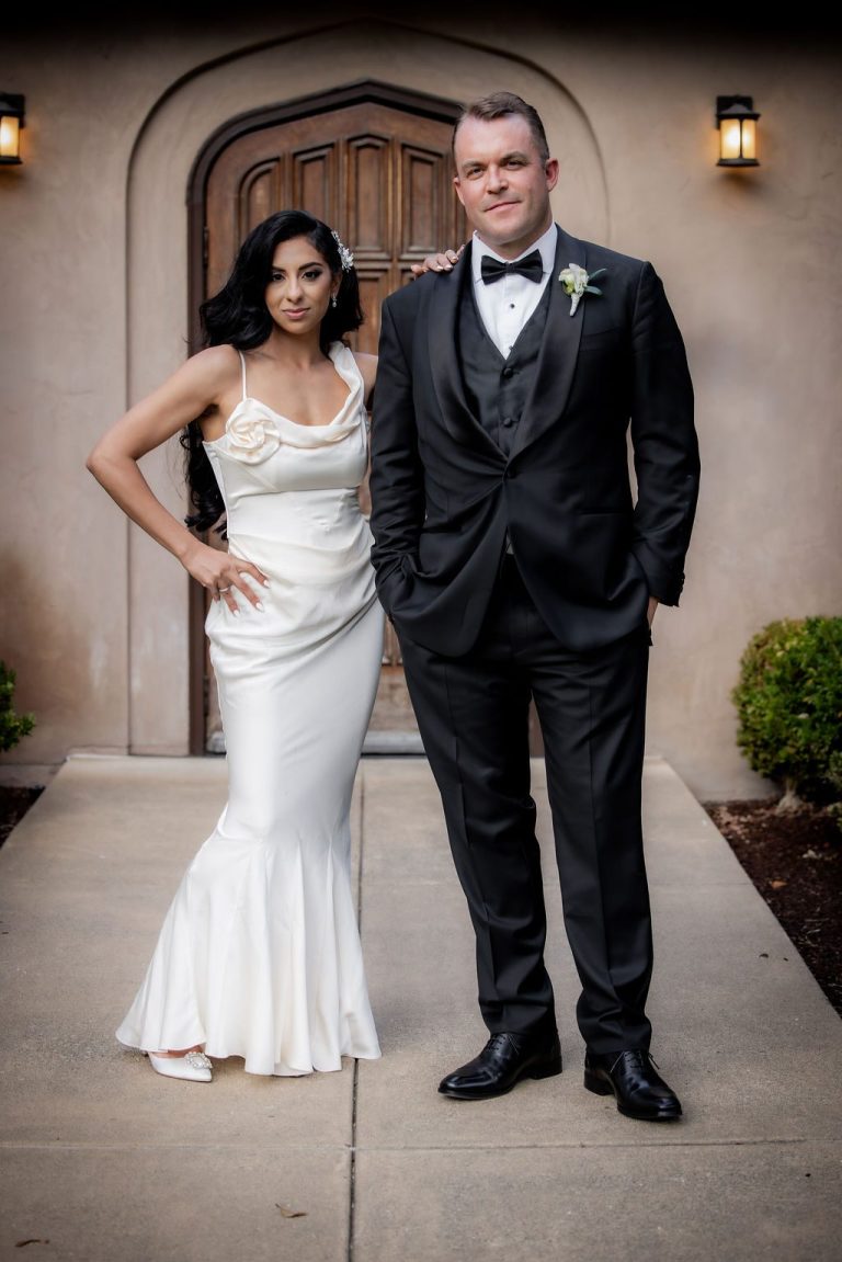 Bride and groom posing formally, hand on hip