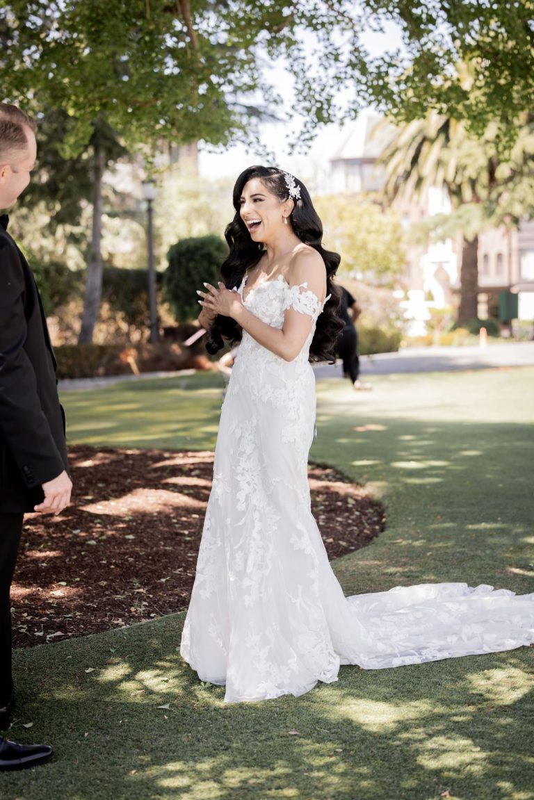 Bride smiling at groom during first look on lawn