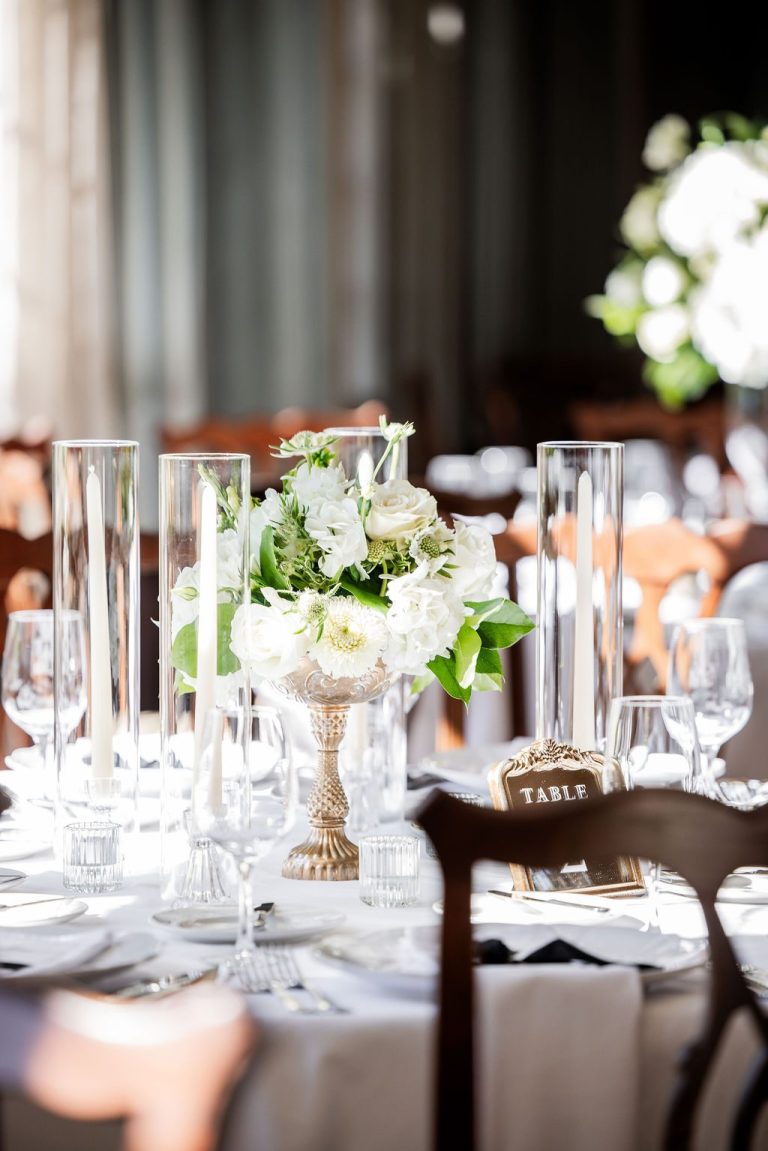 White centerpiece with candles and table number card