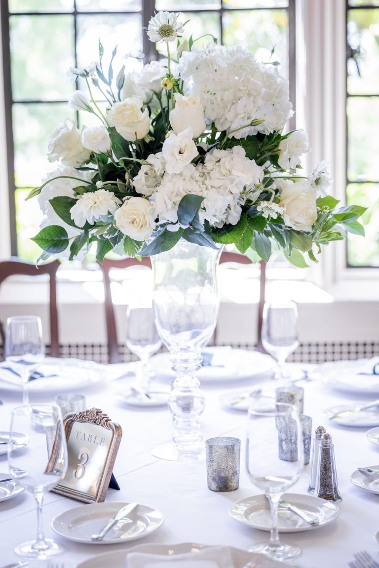 Tall white centerpiece on round reception table