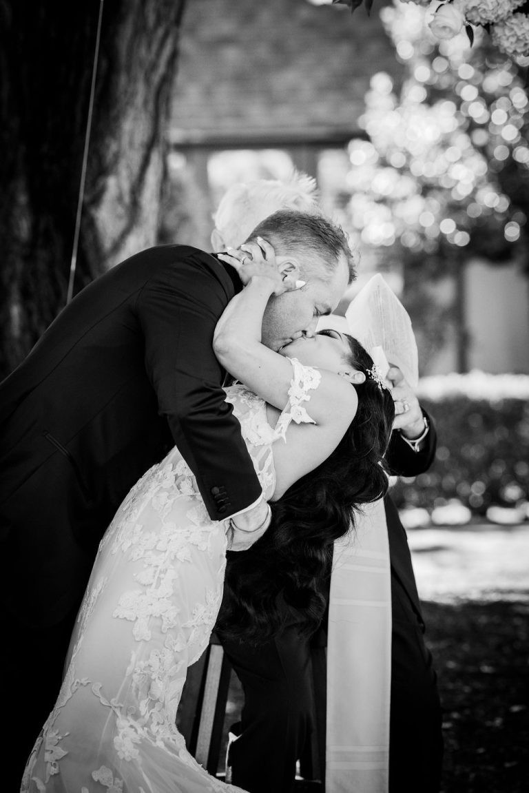 Black and white dramatic dip kiss during ceremony