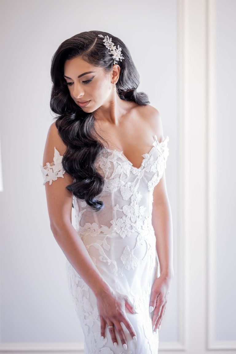 Bride looking down at lace bodice in soft light
