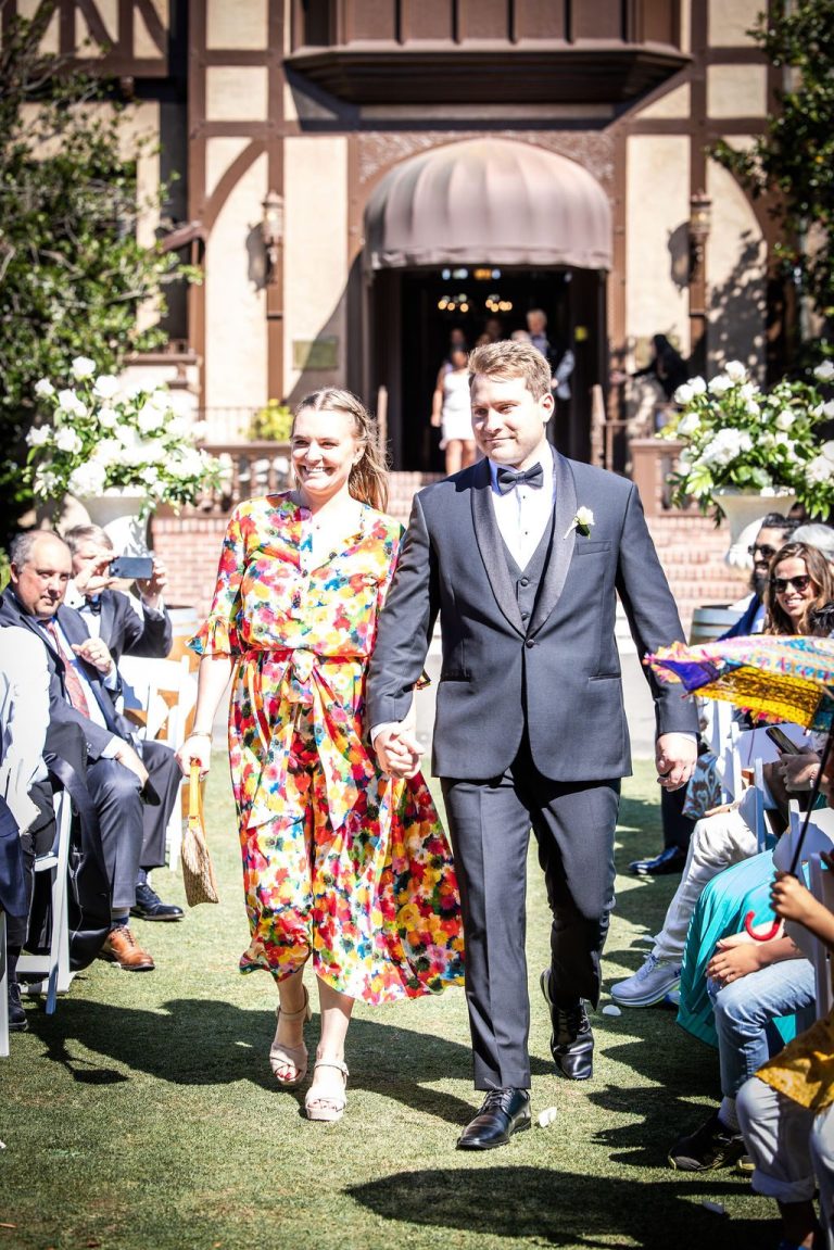 Woman in floral dress and man walking aisle