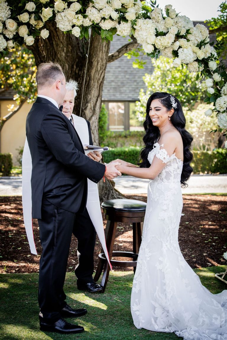 Couple holding hands during outdoor ceremony