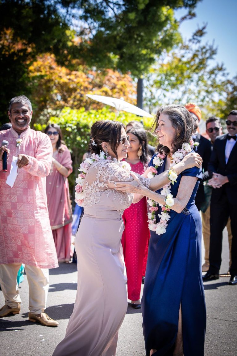 Guests greeting with parasol during outdoor procession