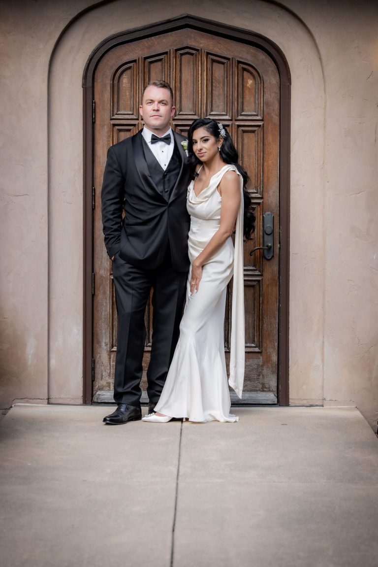 Couple posing in shadowed arched doorway, dramatic light