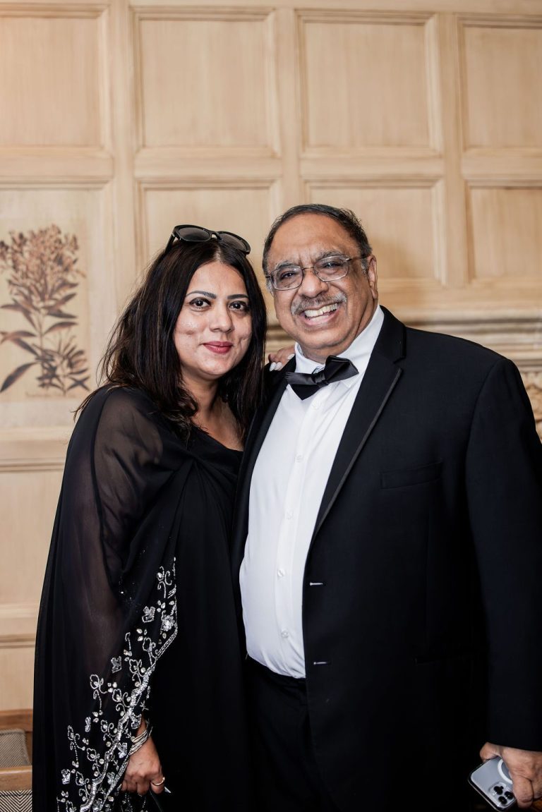 Couple guests posing together in wood paneled room