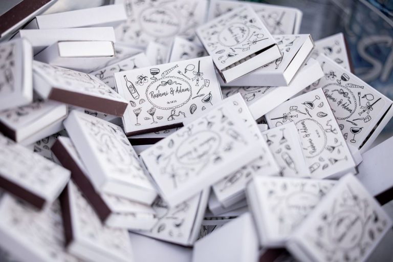 Illustrated wedding favor boxes piled with couple's names