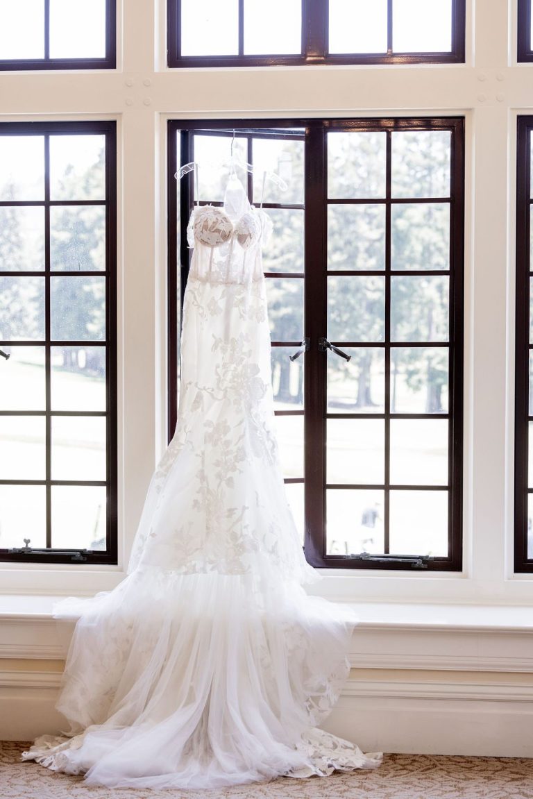 Wedding dress hanging centered in bright window