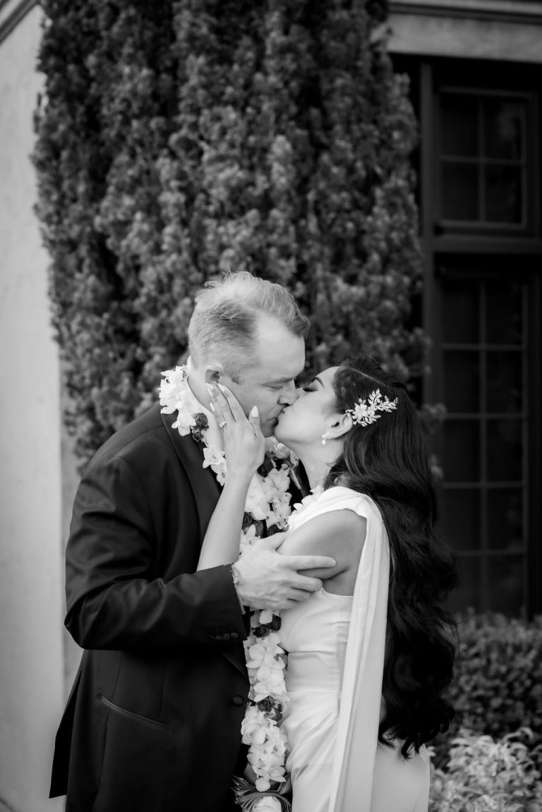 Black and white photo of couple kissing in garden