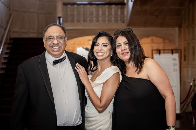 Bride posing with two family members near staircase